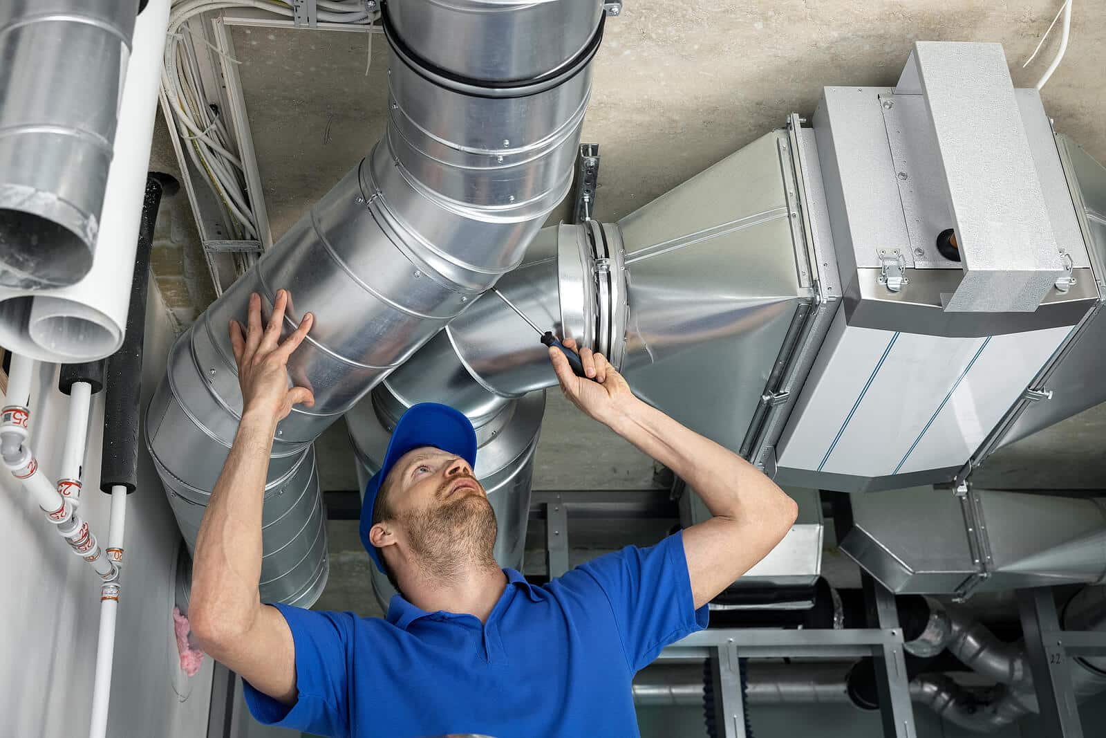 HVAC technician inspecting and repairing air ducts in Pico Rivera