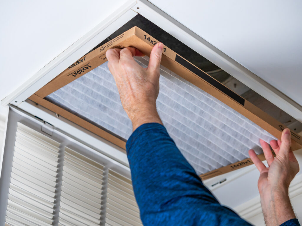 HVAC technician replacing a home air filter in Pico Rivera